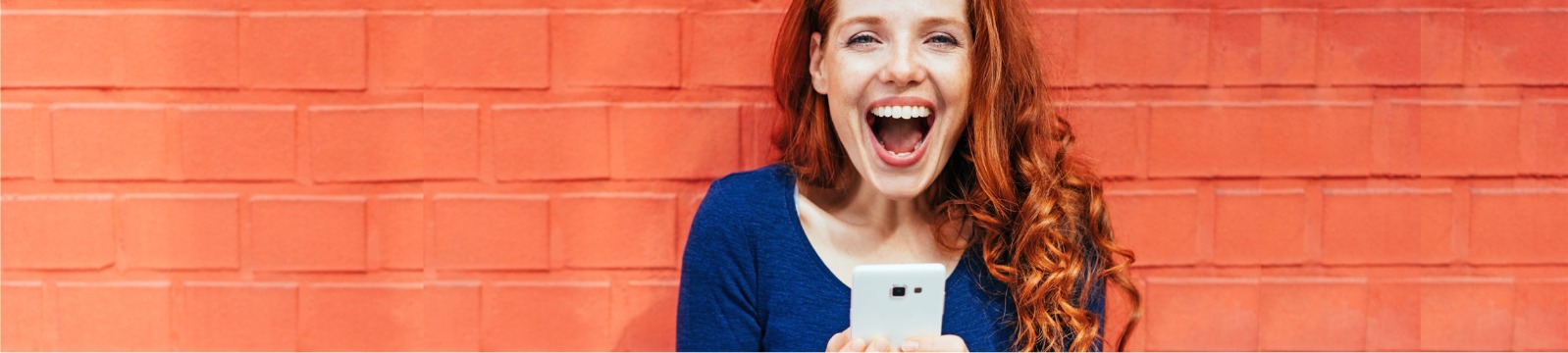 Happy readhead looking at USSCO's goDough mobile banking app on her smart phone.