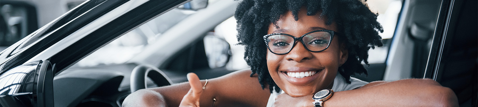 Smiling girl with cool glasses in new car