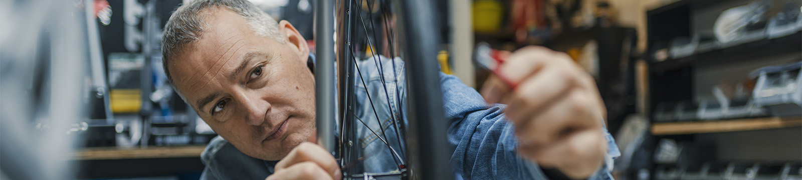 Bike store owner examining bike wheel