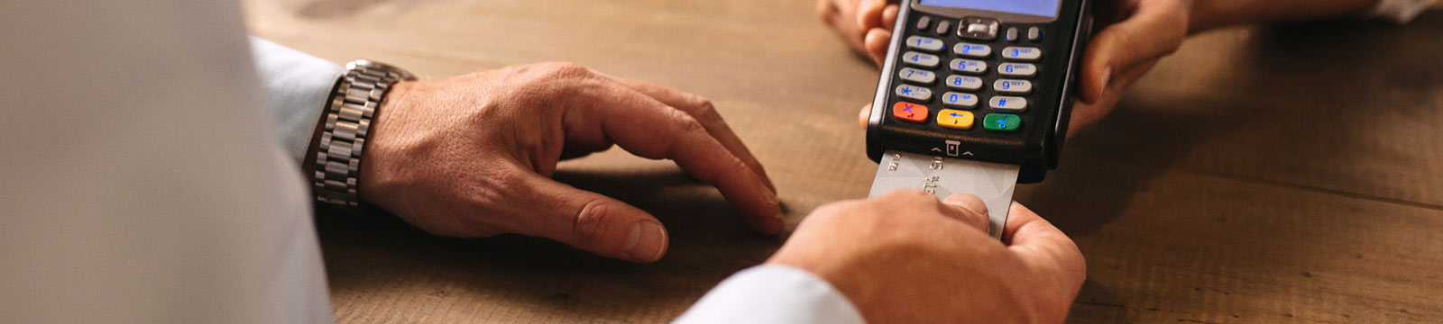 Close up of a person's hands using a credit card reader