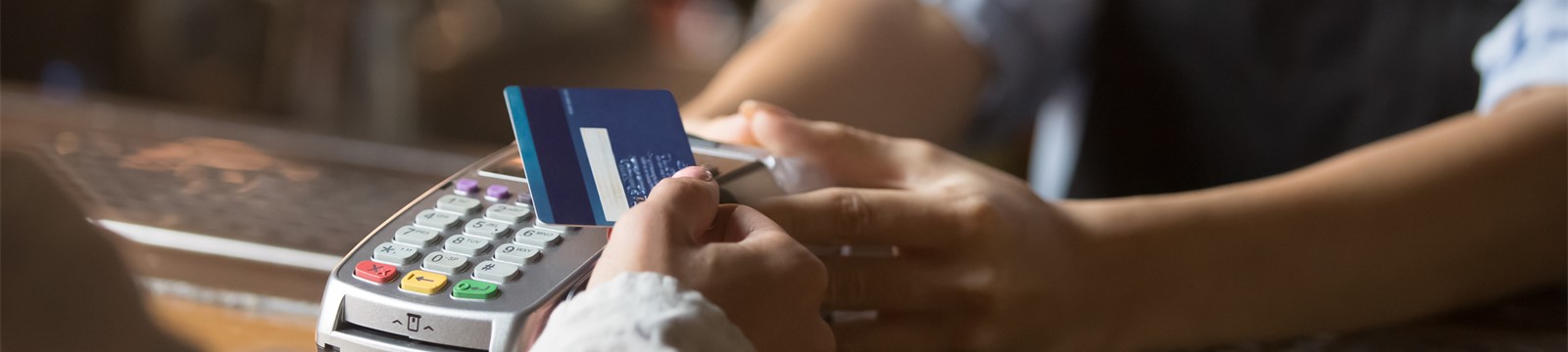 image of woman using USSCO's credit card at point of service terminal.