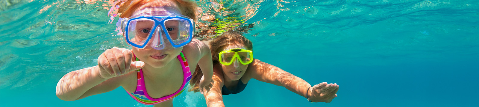 cute redheaded girl swimming toward camera as they snorkel
